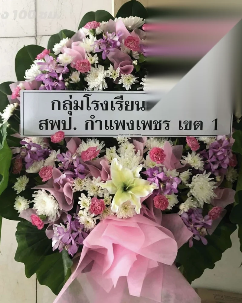 ป้ายชื่อบนพวงหรีดดอกไม้สดที่เขียนสองบรรทัด ระบุชื่อหน่วยงานผู้ส่ง