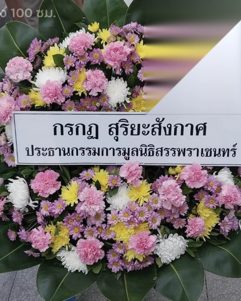 พวงหรีดโทนเหลืองขาวป้ายระบุชื่อและตำแหน่งของผู้ส่งอย่างเป็นทางการ ตั้งอยู่ที่ศาลาวัด