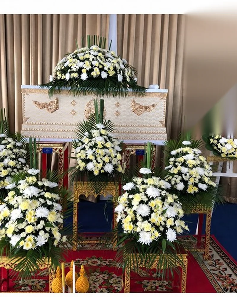 การจัดดอกไม้หน้าหีบโทนขาวเหลืองภายในศาลาบำเพ็ญกุศลของวัดในกรุงเทพฯ